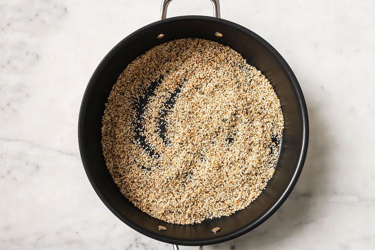 Roasting sesame seeds and hemp seeds in a frying pan.