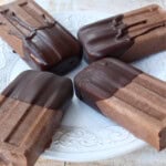 Four sugar free fudgesicles with chocolate coating on a plate.
