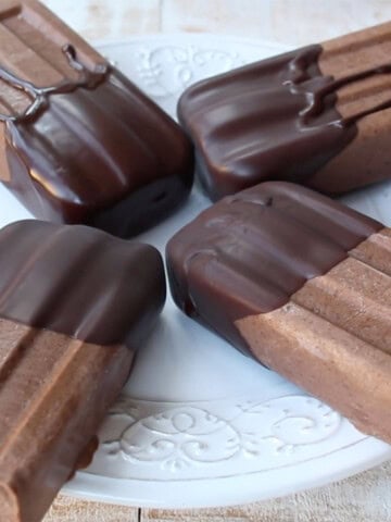 Four sugar free fudgesicles with chocolate coating on a plate.