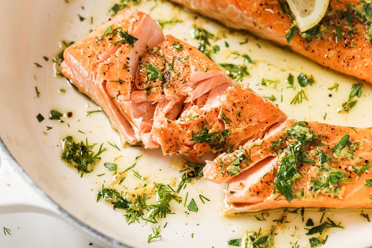 Flaked salmon fillets with herb olive oil dressing.