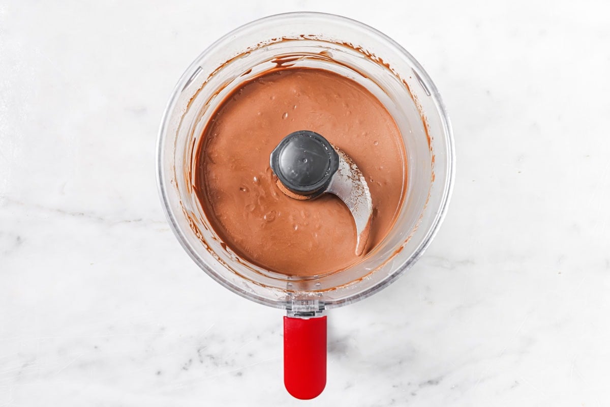 Chocolate pudding mixture in a food processor bowl.