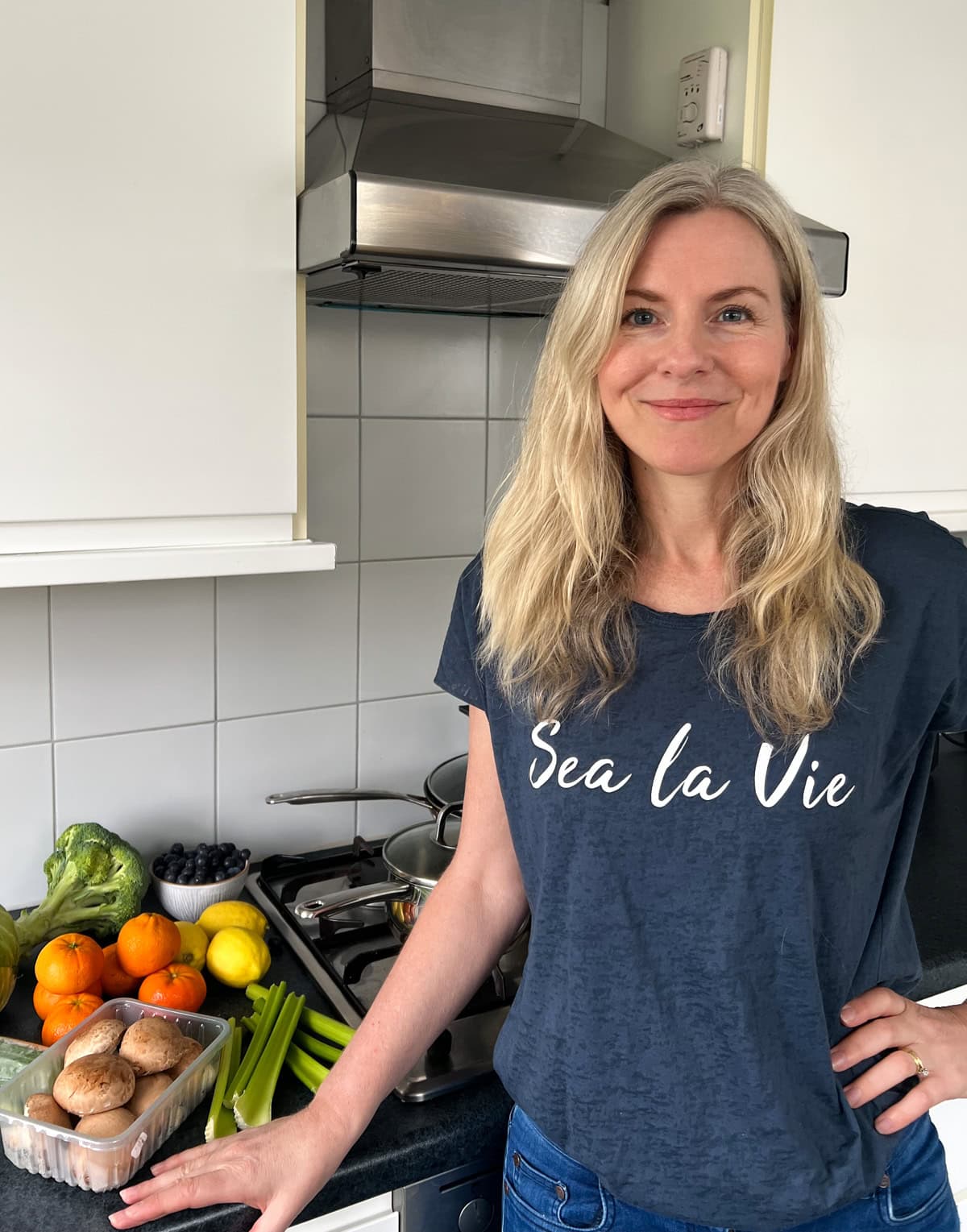 Katrin Nuernberger in her kitchen with fruit and vegetables on the counter.