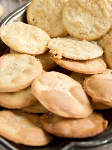 Round almond flour crackers on a silver tray.