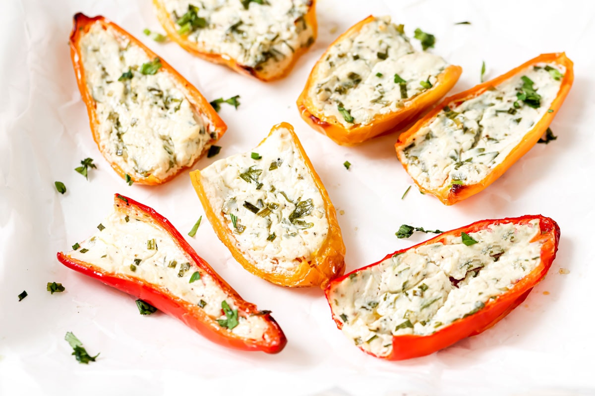 Baked stuffed mini peppers on parchment paper.