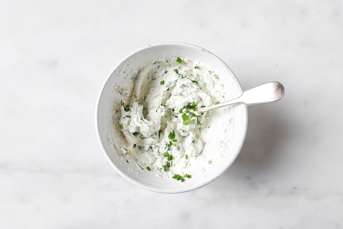 Cream cheese filling in a bowl with a spoon.