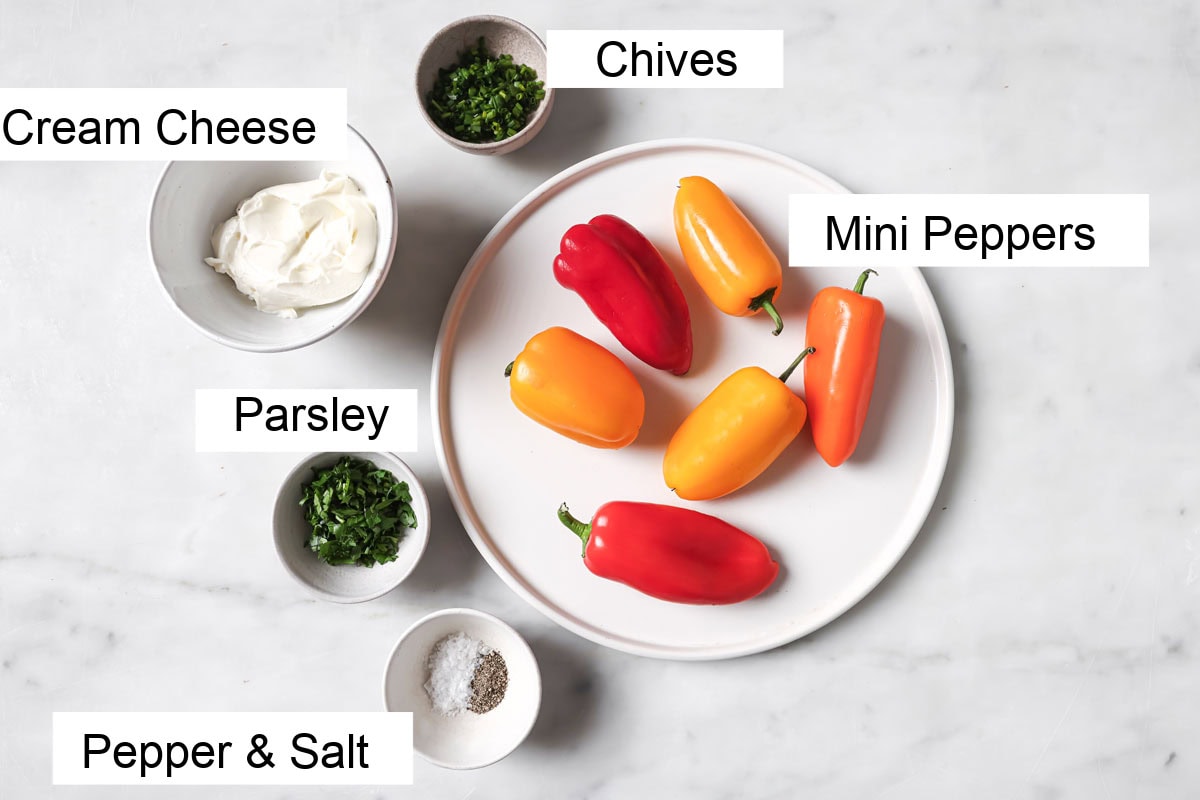 Ingredients to make stuffed mini peppers, measured into bowls and labelled.