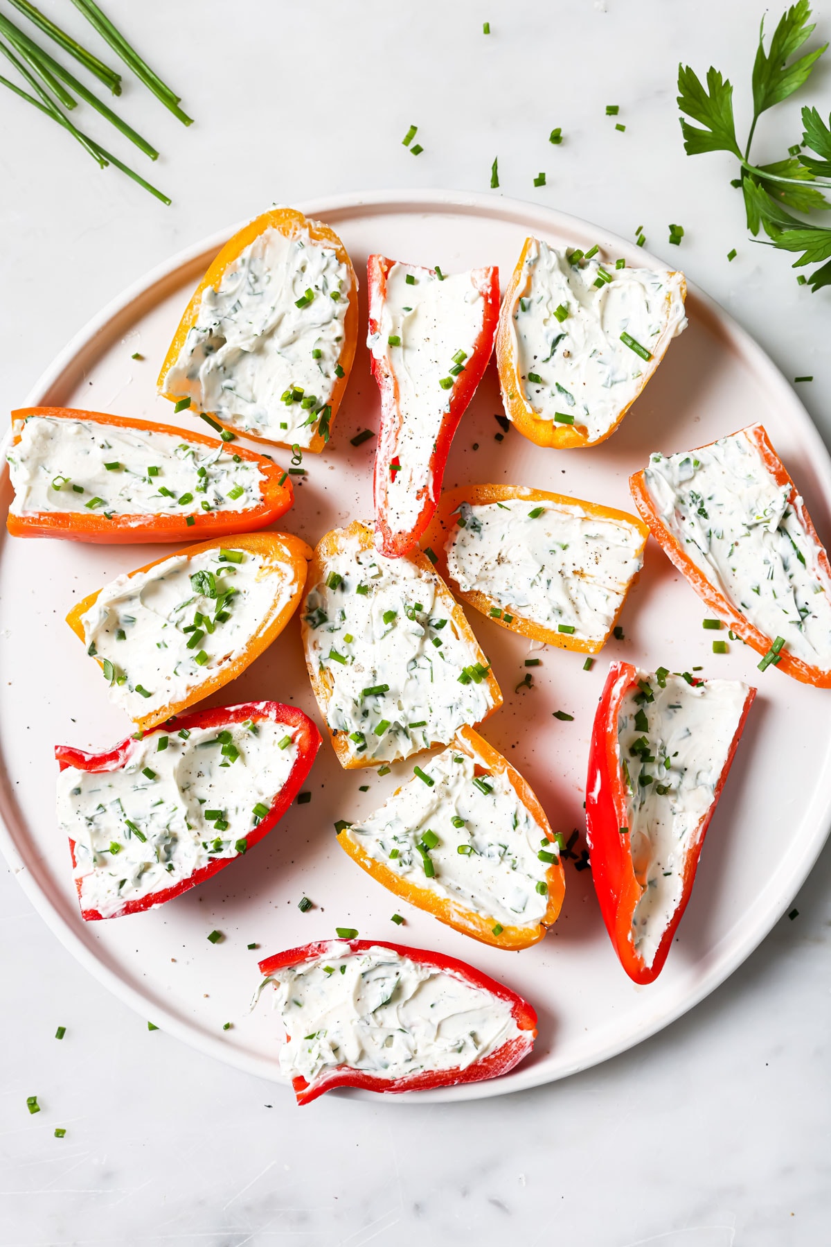 Cream cheese stuffed mini peppers on a plate.