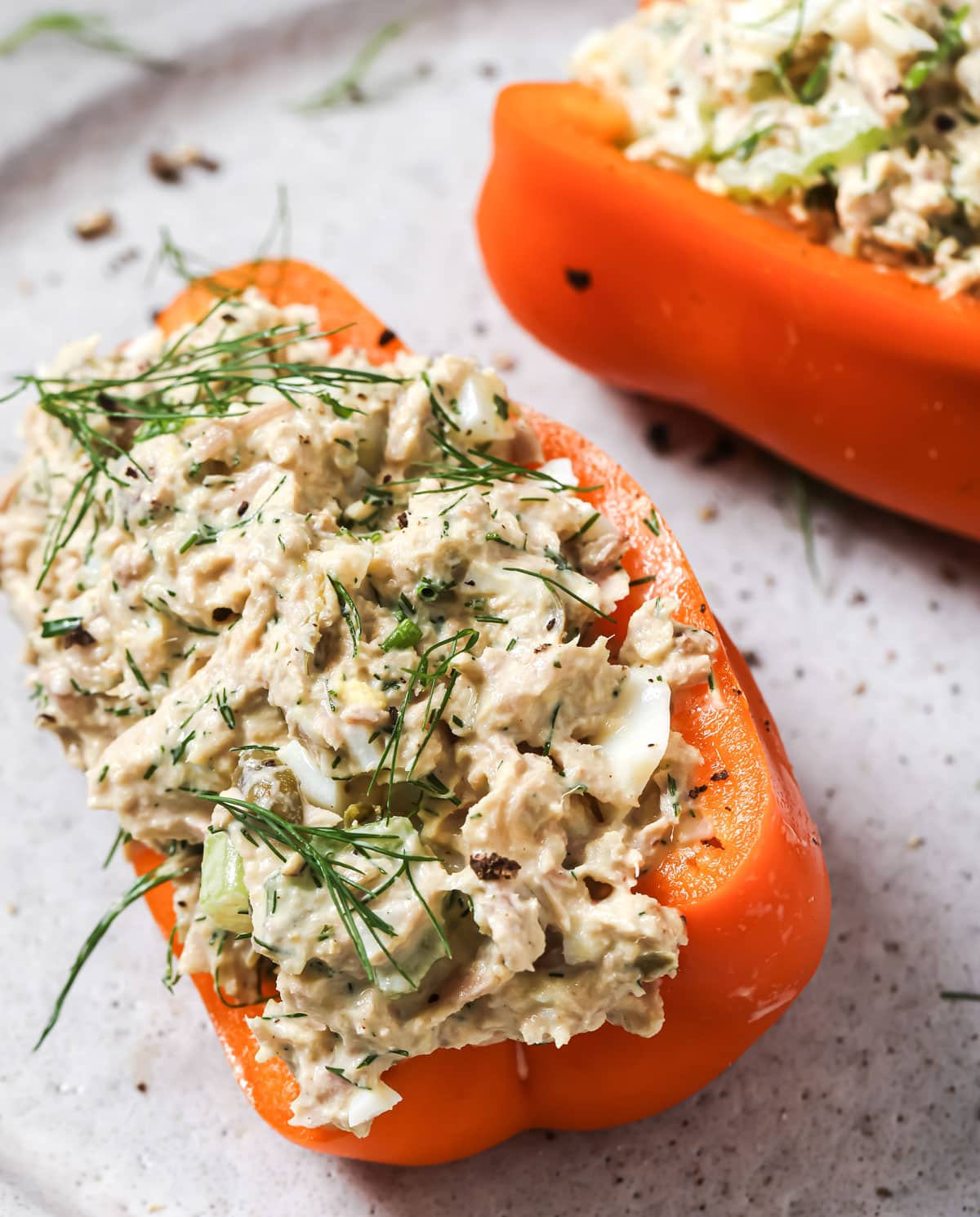 Tuna egg salad filled into red pepper halves, topped with fresh dill.