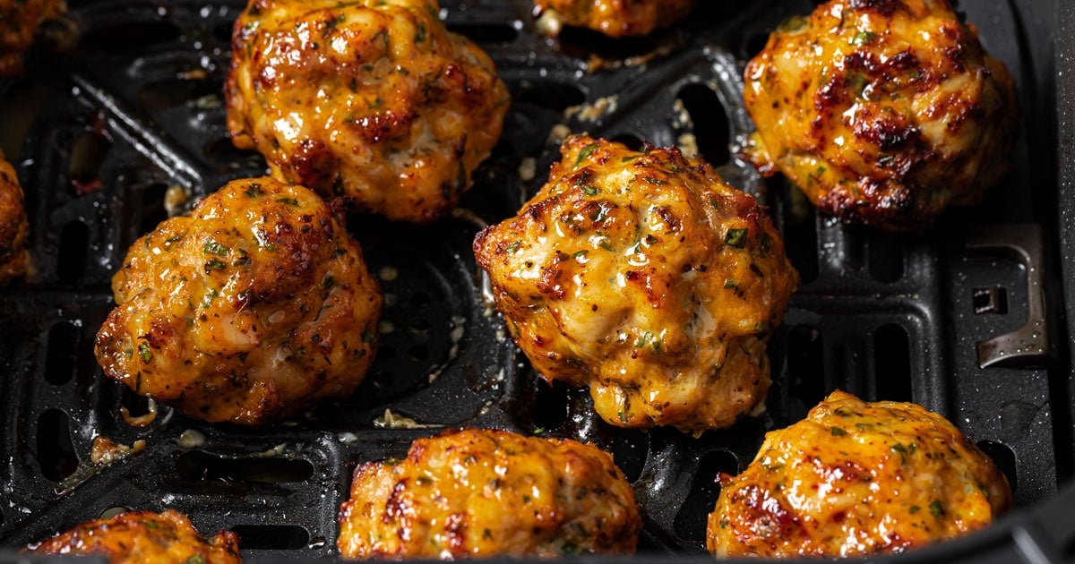 Chicken meatballs in an air fryer basket.