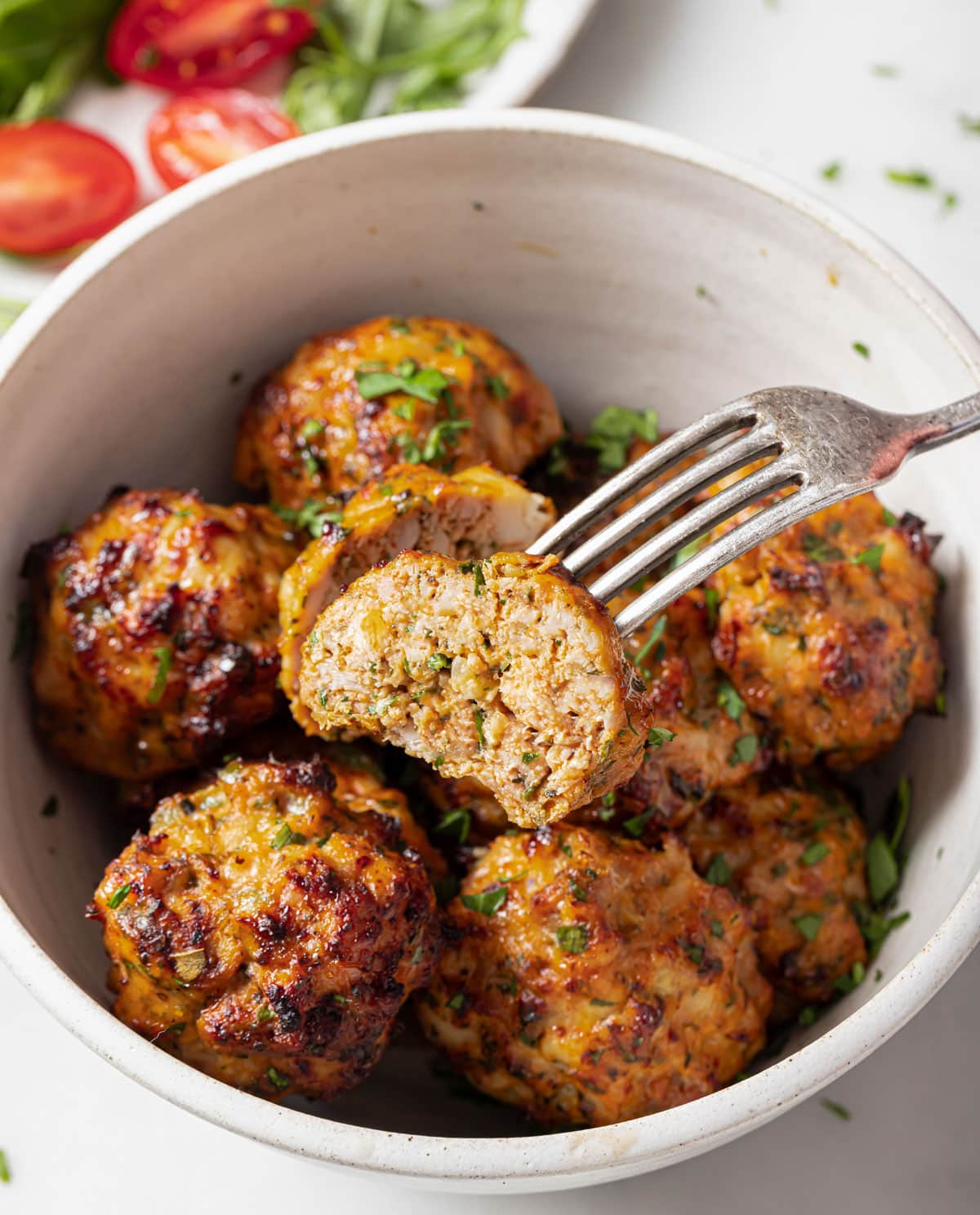 A fork with a halved meatball, showing the juicy inside.