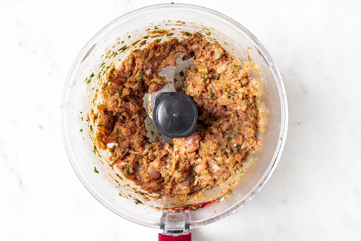 Blended chicken meatball mixture in a food processor bowl.