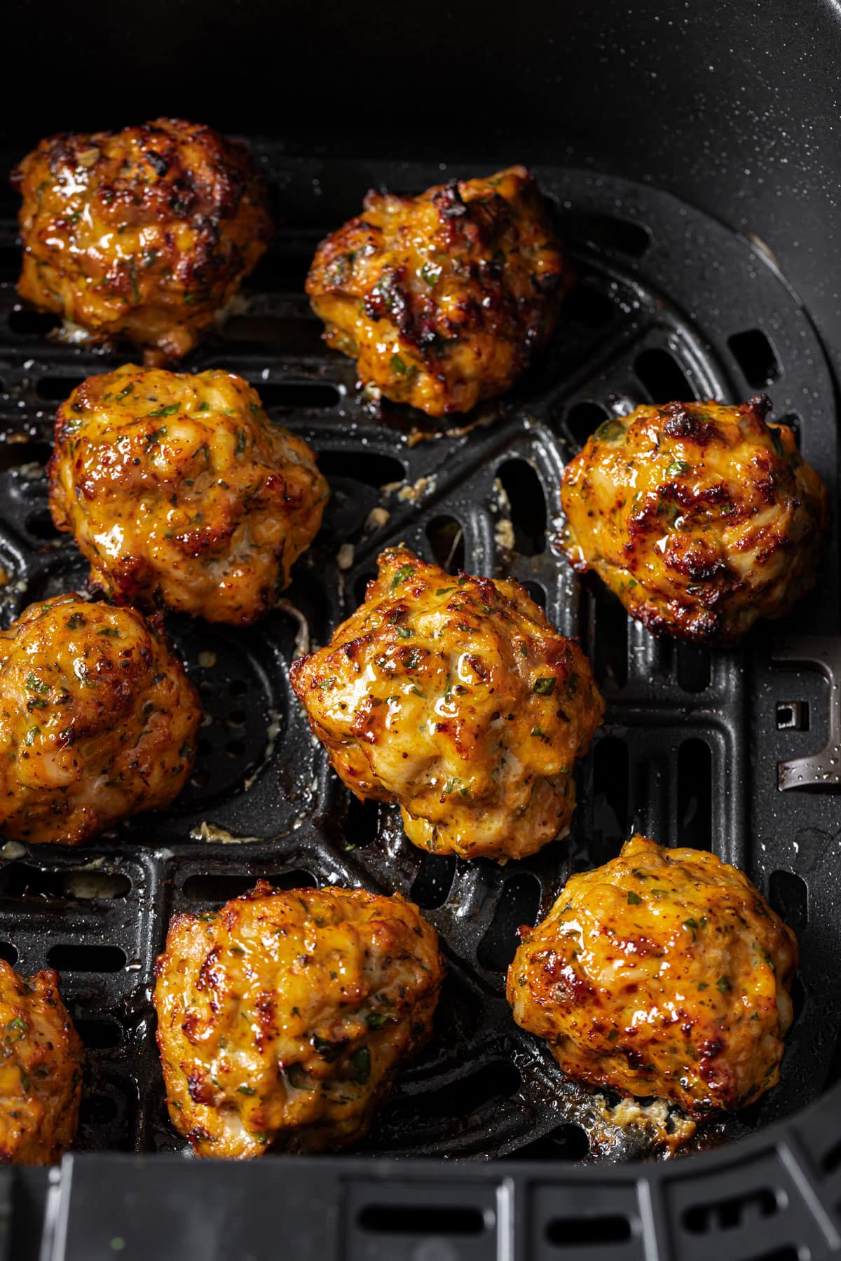 Chicken meatballs in the air fryer basket.