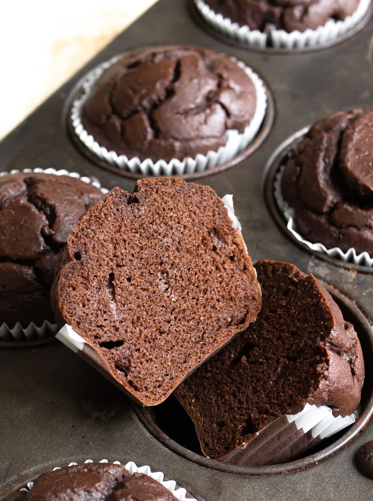 Chocolate muffin sliced in half, showing the fluffy crumb.