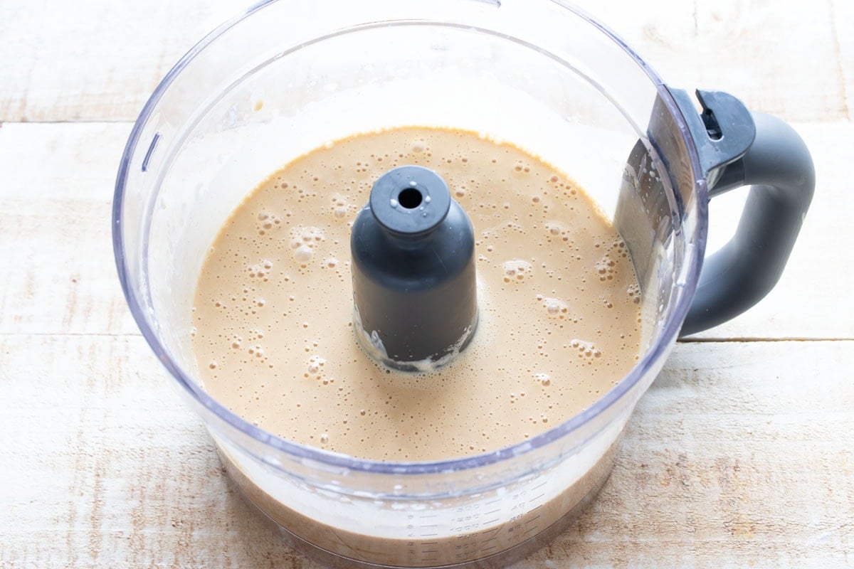 Blended wet ingredients in a food processor bowl.