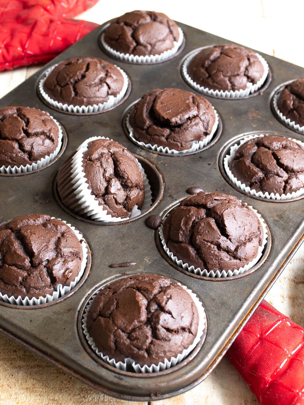 Chocolate protein muffins in a muffin pan.