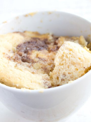 A coconut flour mug cake in a mug and a spoon.