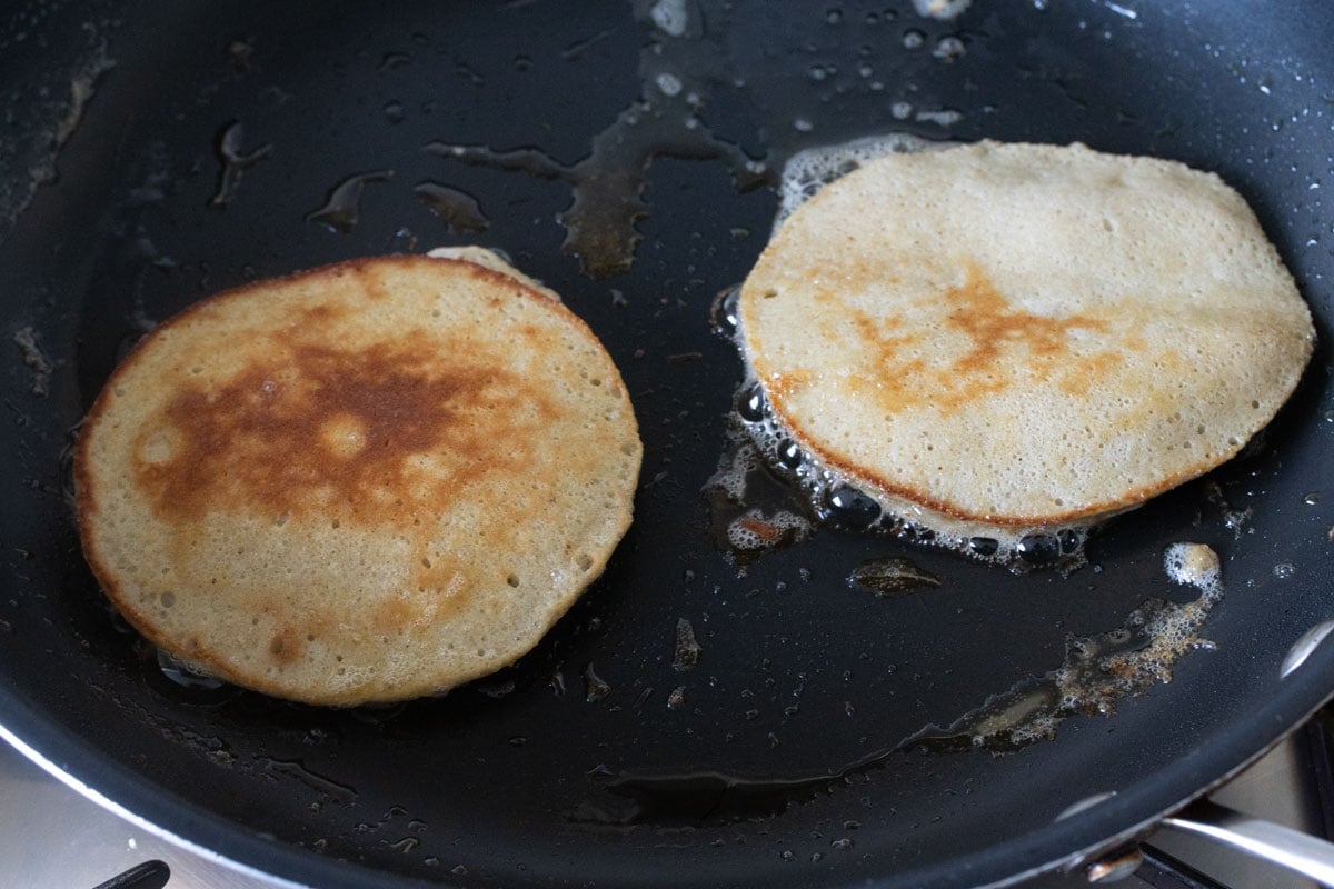 2 pancakes in a frying pan.