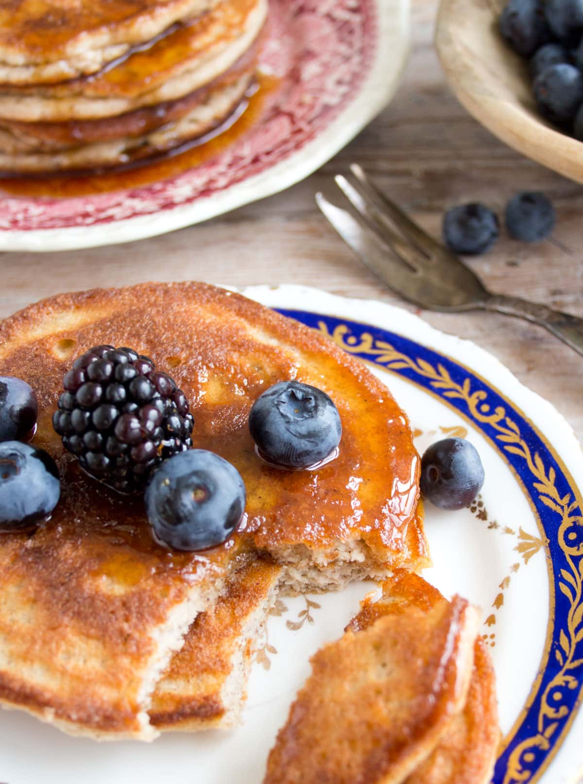 Cinnamon pancakes with berries and sugar free syrup on a plate.