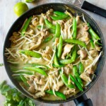 Keto Thai green curry with chicken, sugarsnap peas and bean sprouts in a frying pan.