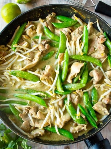 Keto Thai green curry with chicken, sugarsnap peas and bean sprouts in a frying pan.