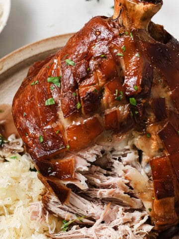 Schweinshaxe on a plate with sauerkraut.