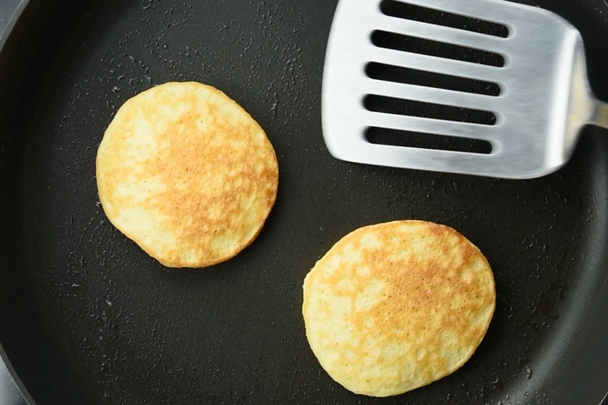 Browned coconut flour pancakes in a frying pan.