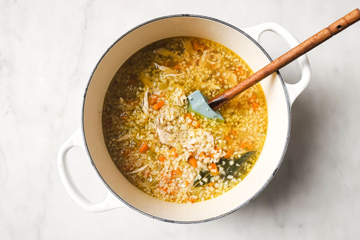 Cauliflower rice in a pot with lemon chicken soup.