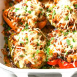 Ground turkey stuffe peppers topped with melted cheese and chopped parsley.