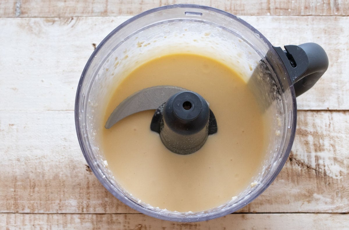 Blended cottage cheese, cheese and eggs in a food processor bowl.