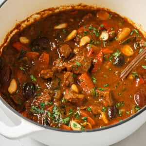 Moroccan lamb stew with black olives and almonds in a pot.