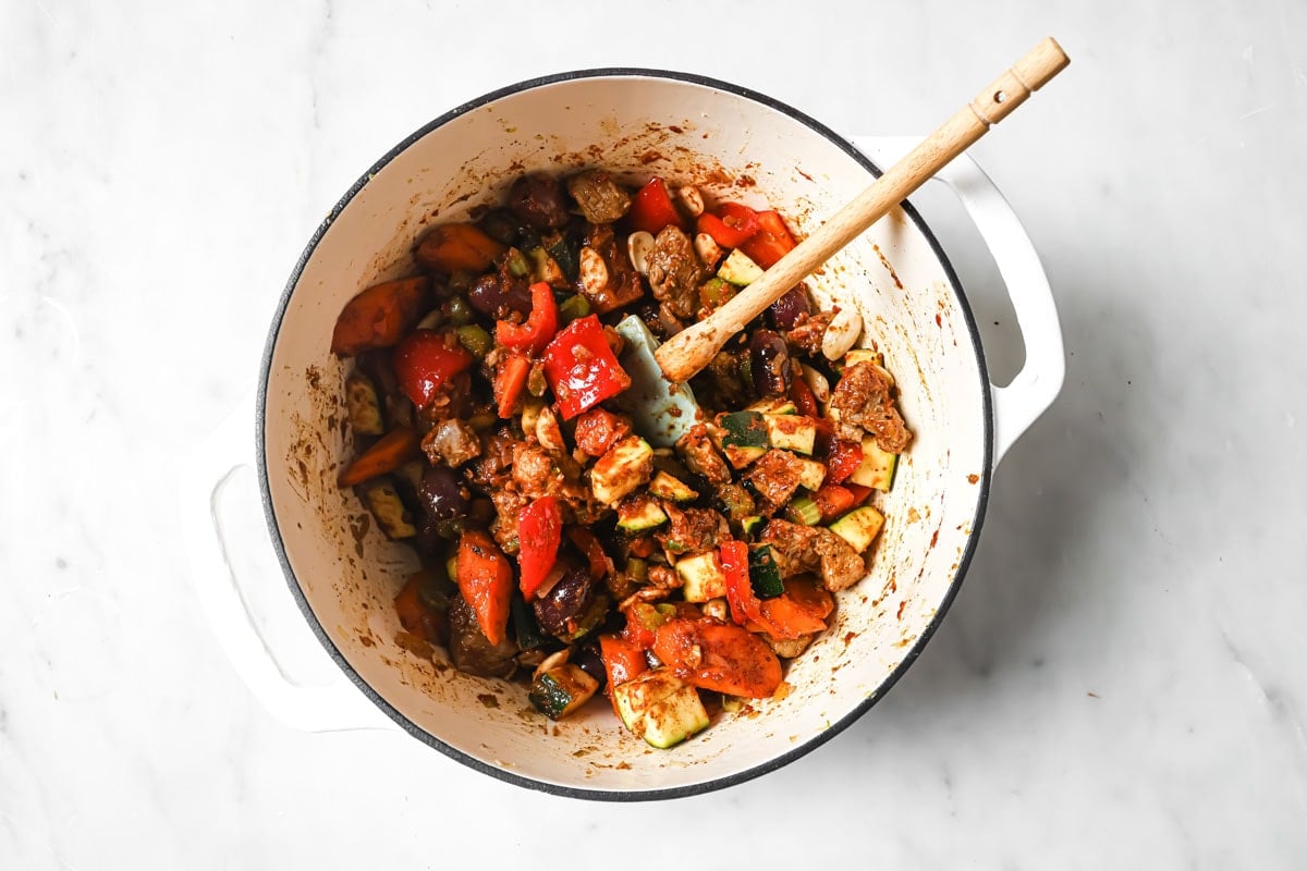 Vegetables and lamb with tomato paste in the pot.