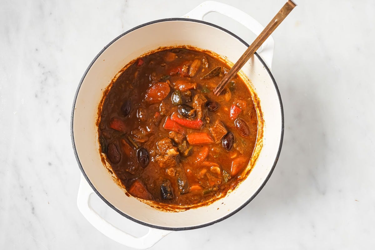 The thickened lamb stew in a pot with a ladle.