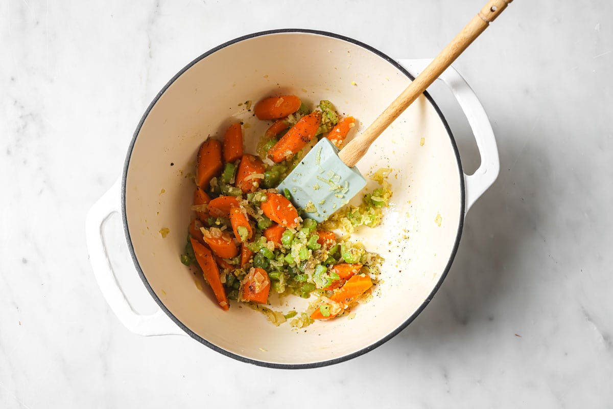 Frying chopped vegetables and garlic in a pot.