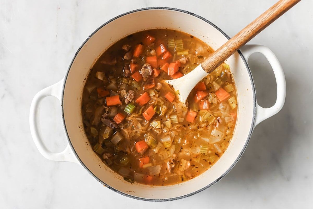 Adding the sauerkaut to the soup.