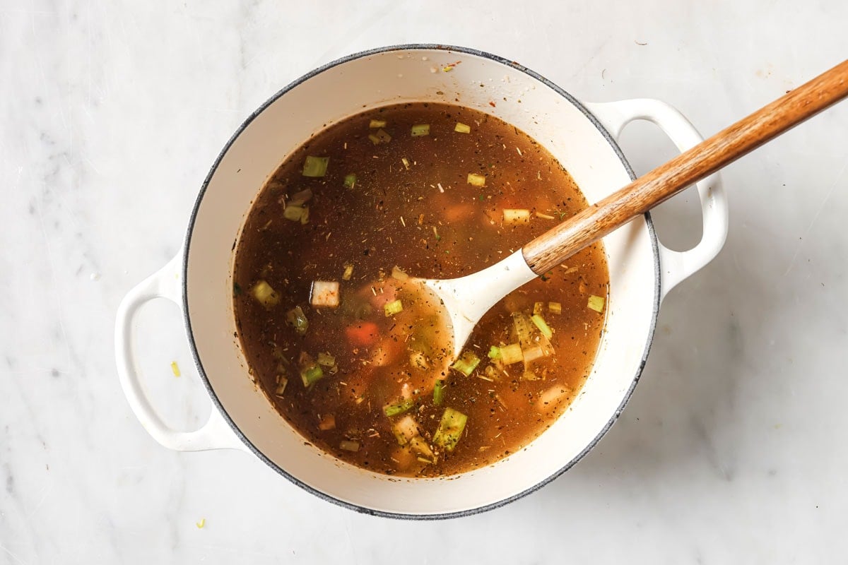 Adding broth to the soup.