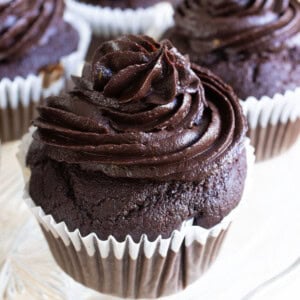 A keto chocolate cupcake topped with chocolate avocado frosting.