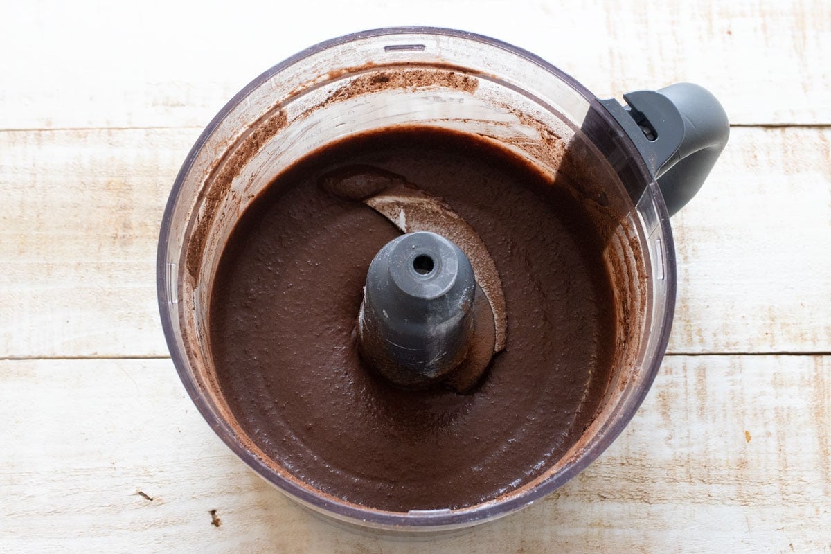 Chocolate batter in a foor processor bowl.