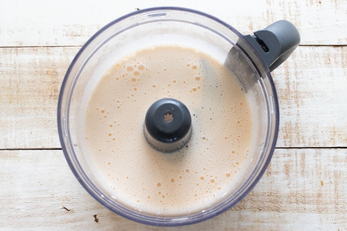 Blended eggs and coconut oil in a food processor bowl.