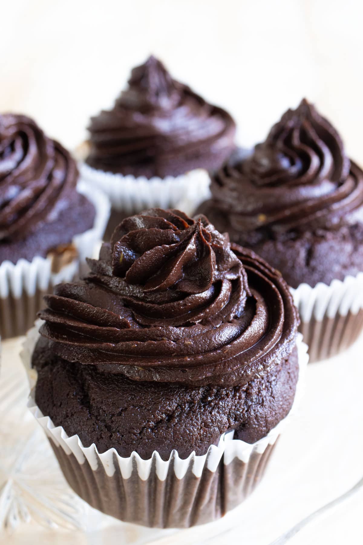 Keto chocolate cupcakes with avocado frosting on a tray.