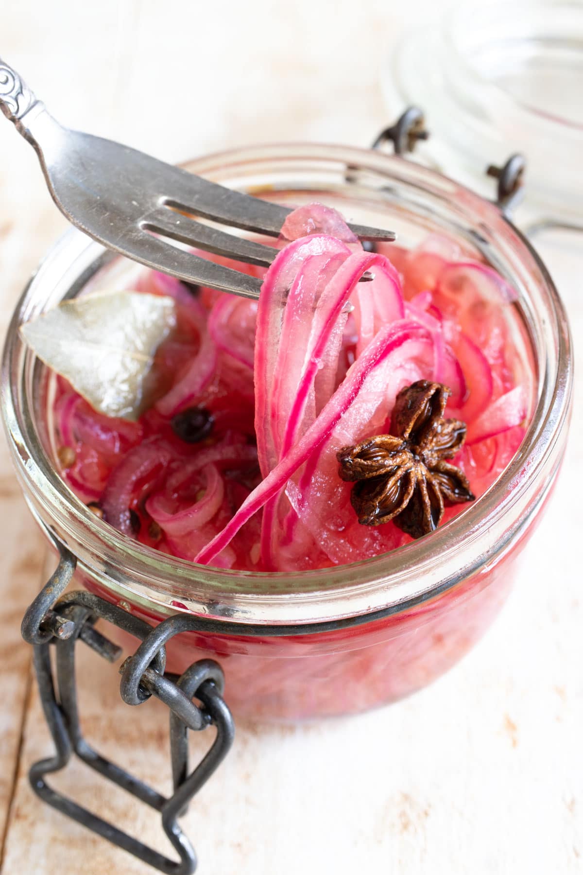 A jar with pickled onions and a fork.