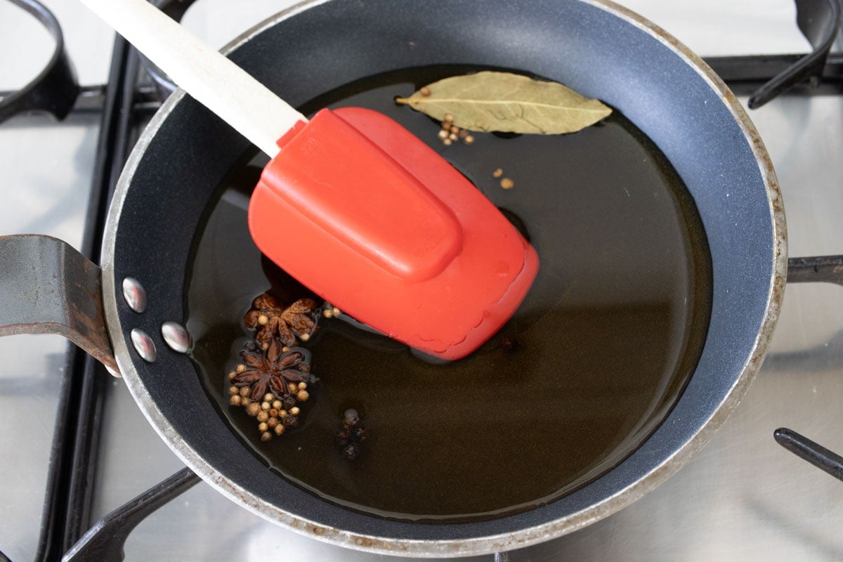 Dissolving sweetener and salt with spices in vinegar in a pan on the stovetop.