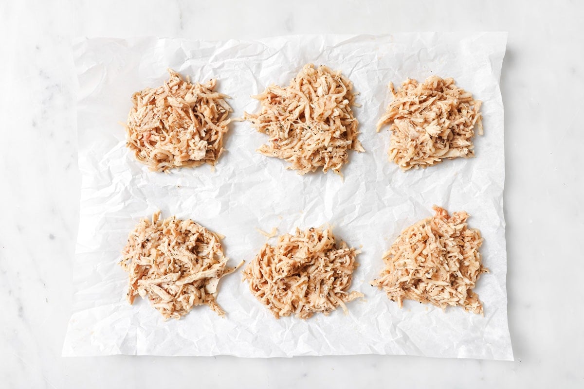 Chicken fritter mixture before frying on parchment paper.