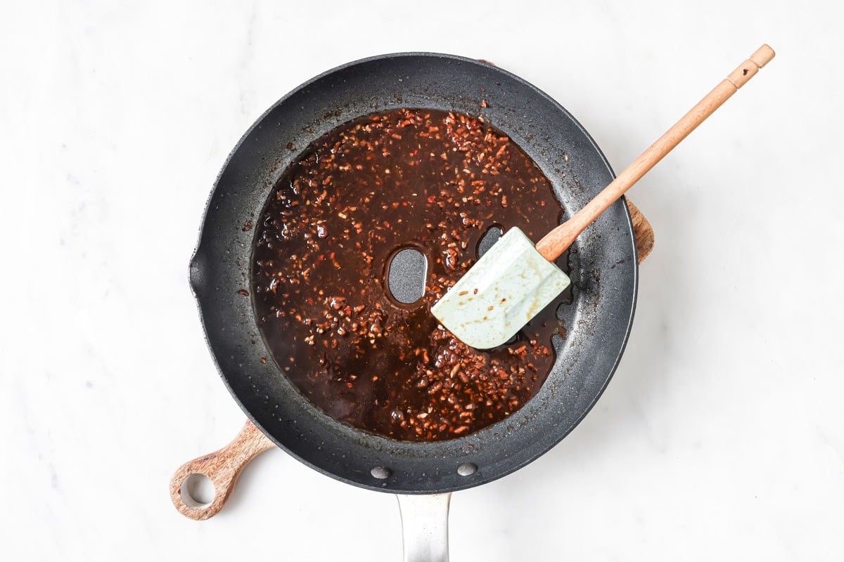 Making a sauce by adding tamari to the spices in a frying pan.