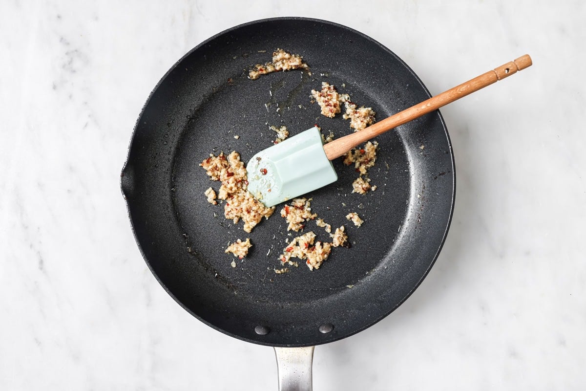 Fryig garlic, ginger and spices in a frying pan.