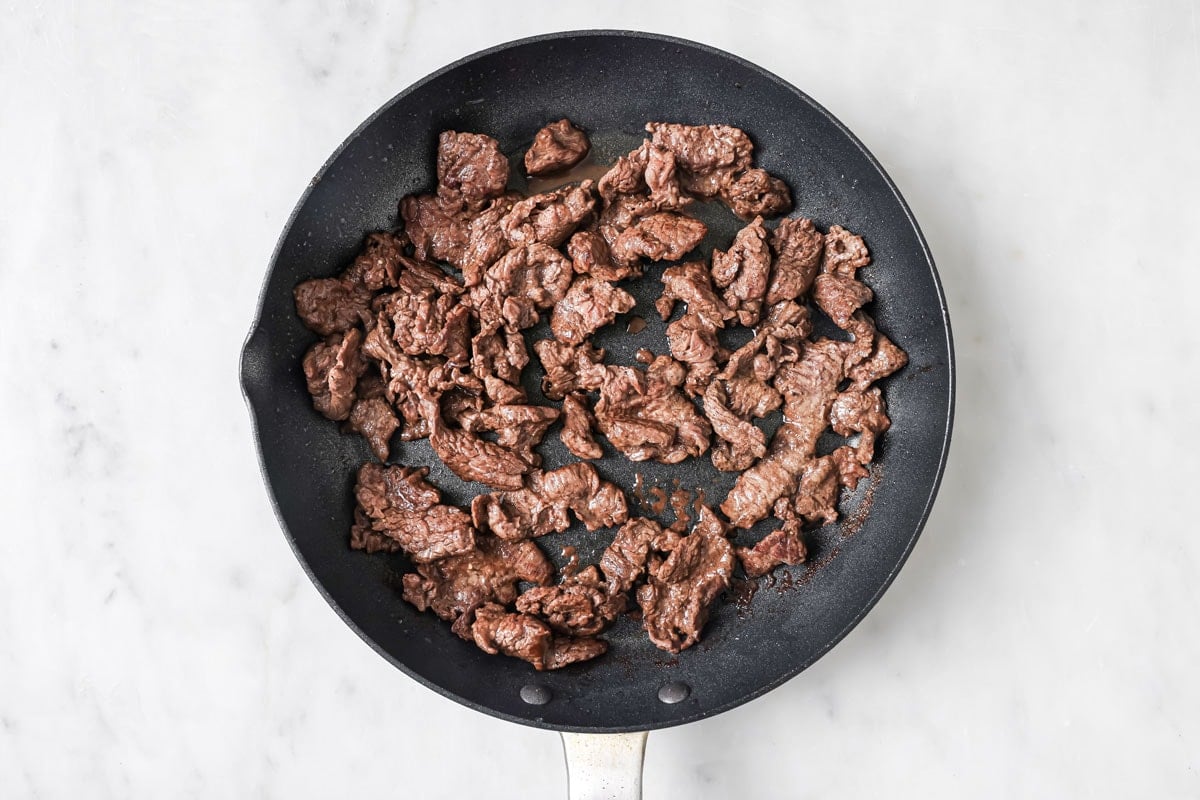 Frying chopped beef in a frying pan.