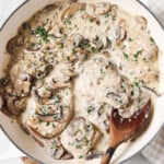 A pan with chicken tenders in a creamy mushroom sauce.