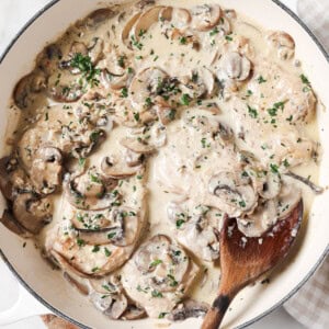 A pan with chicken tenders in a creamy mushroom sauce.