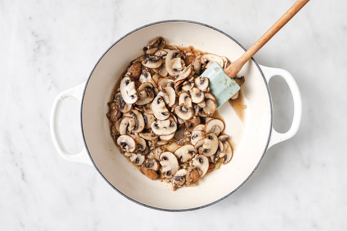 Frying sliced mushrooms in a pan.