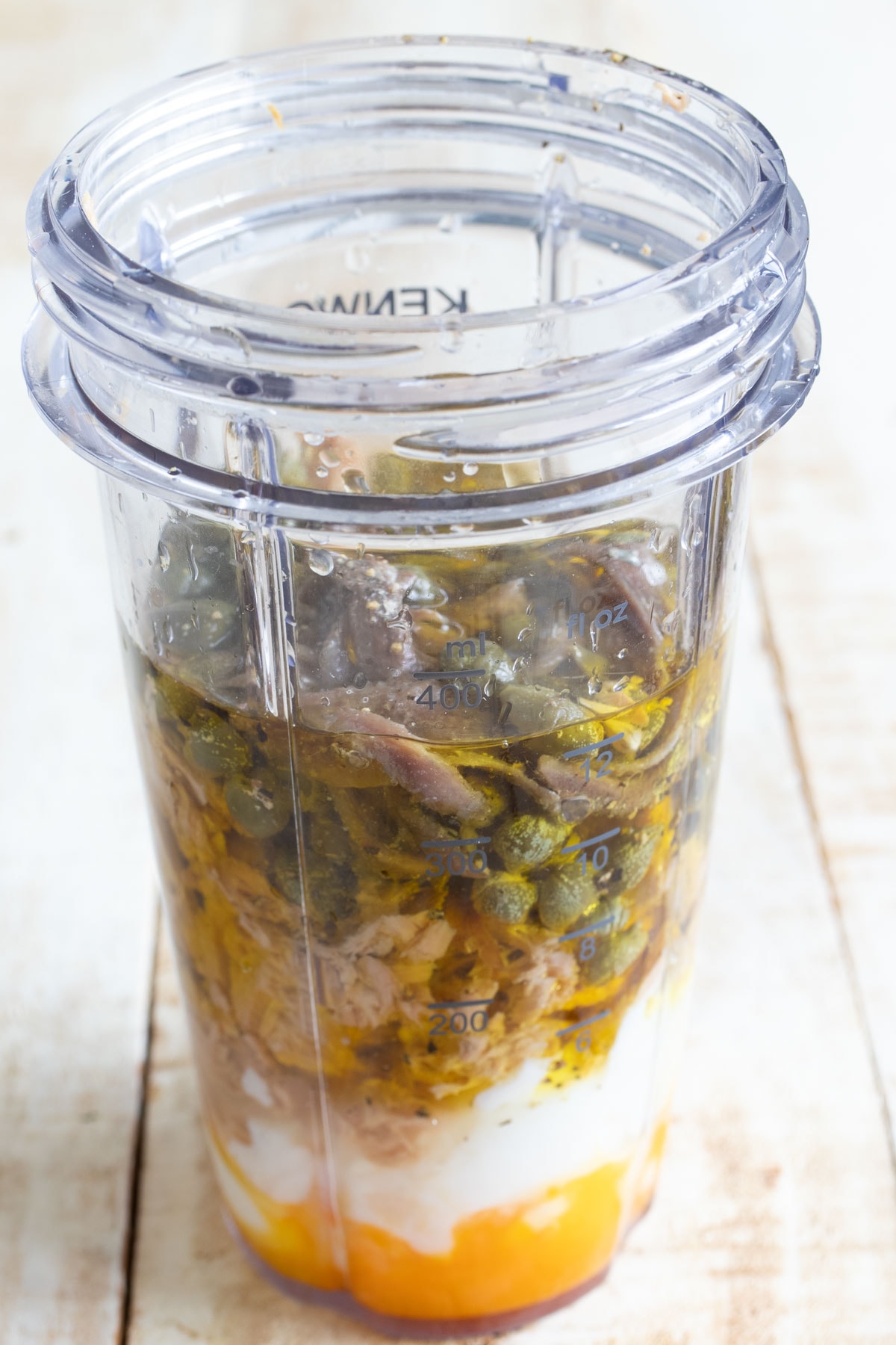 Tuna, boiled eggs, capers and other ingredients in a blender jug.