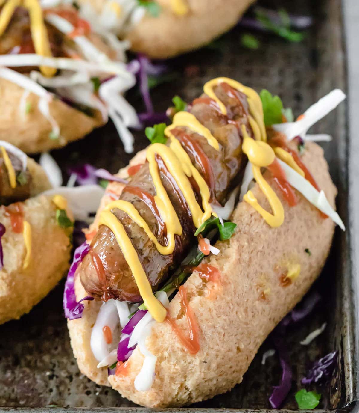 low carb hot dog buns filled with sausage, salad and mustard and ketchup